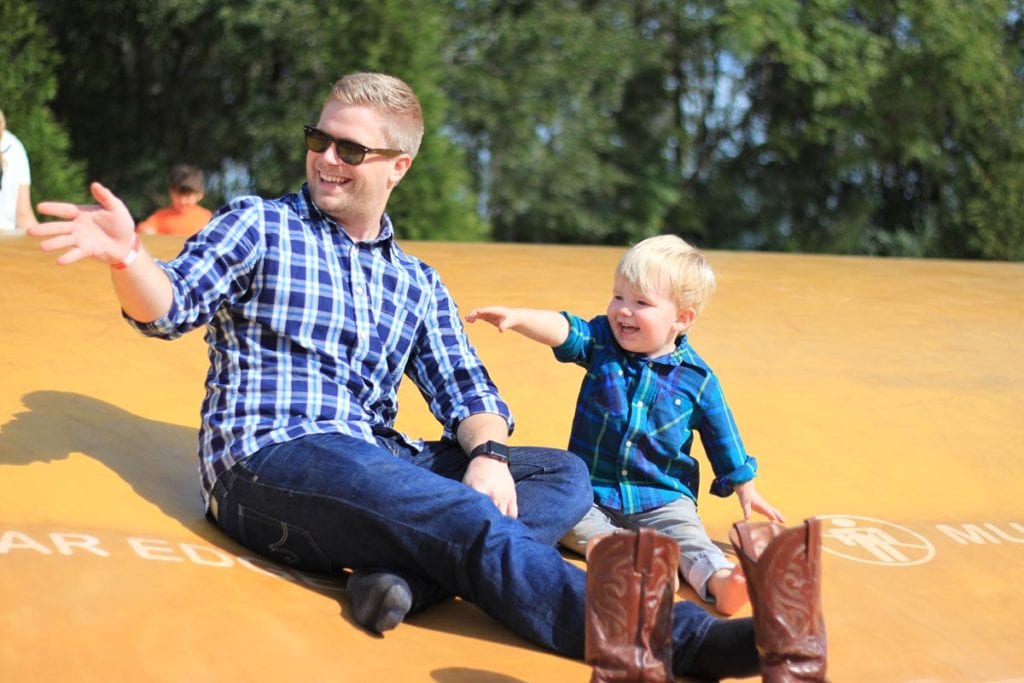 Father and son sitting on a jumping pillow