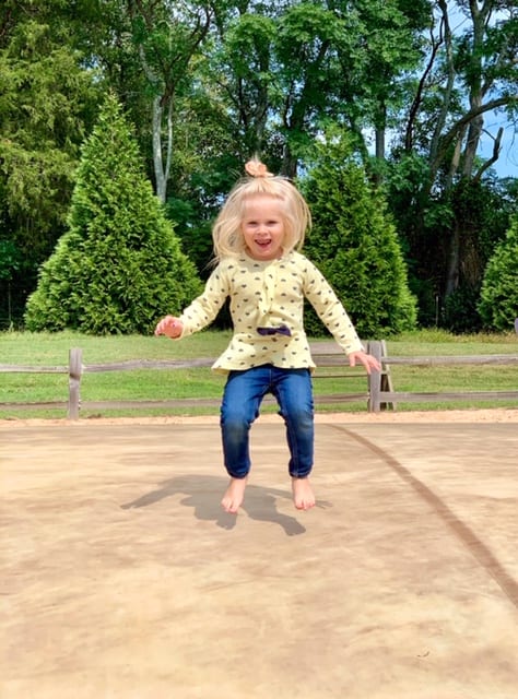 girl jumping in the air on a jumping pillow 